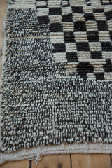 Close-up of vintage Moroccan rug showing salt and pepper knotting and textured checkered pattern.