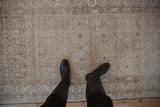 Detail of vintage Hamadan runner with distressed texture, faded Herati pattern, and soft beige palette.