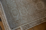 Distressed vintage Hamadan runner detail, featuring faded Herati pattern and textured neutral tones.