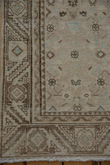 Distressed Hamadan runner corner, showcasing worn pile, traditional floral border, and powder blue Herati motif.