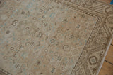 Close-up of distressed vintage Hamadan runner pile, revealing muted blue motifs and geometric border detail.