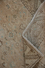 Distressed Hamadan runner pile in soft ivory, powder blue motifs, and geometric underside when folded.