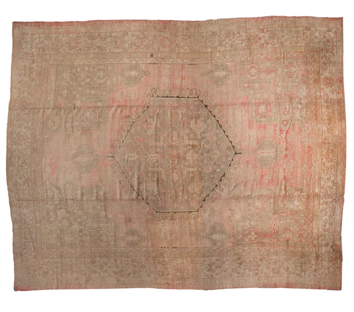 Vintage distressed Oushak carpet with a geometric medallion in faded rose, silver, and beige tones.