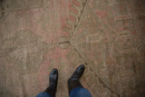 High and low pile texture on a distressed Oushak carpet in dusty rose and beige tones.