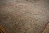 Soft, varied pile texture with faded rose and silver tones on a distressed Oushak carpet.