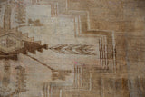 Distressed Kars carpet pile with geometric primitive relief, abrashed beige, coffee, and sand tones.