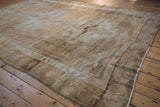 Distressed Kars carpet texture with beige and brown geometric patterns and border.