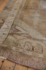 Distressed texture of a vintage Kars carpet, with primitive geometric motifs in beige and pink.