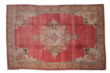 Distressed vintage Oushak carpet with a large center medallion on an abrashed dusty red and sand field.