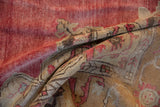 A vintage distressed Oushak carpet folded to reveal its soft, low pile and abrashed texture.