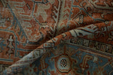 Distressed Mehrivan rug's folded pile, featuring geometric vines in pale terracotta and dusty blue.