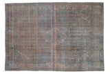 Distressed Persian Bijar carpet with a stylized medallion, showcasing heavy abrashes in pale pink and dusty blue.