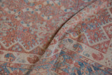 A folded view showing the soft handle and worn texture of the distressed Persian carpet.