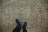 Faded pale blue geometric-floral pattern on a distressed vintage Malayer runner, with black boots.