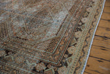 Vintage distressed West Persian carpet texture in faded terracotta, dusty teal, and brown tones.