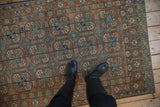 Vintage distressed Afghani Belouch rug with chestnut, cobalt blue, and olive green gul motifs.