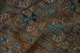 Textured detail of distressed Afghani Belouch rug's elephant footprint guls in chestnut and dusty blue.