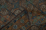 Distressed Afghani Belouch geometric rug, folded to show worn pile in chestnut, cobalt, and olive.