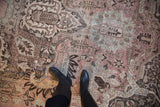 Faded dusty mauve and charcoal floral motifs on this distressed vintage Khoy rug.
