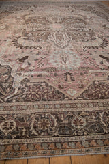 Distressed vintage Khoy carpet displaying faded mauve, charcoal, and powder blue floral motifs.