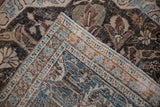 Detail of vintage distressed Khoy rug corner, showing worn floral pile and striped selvedge.