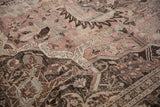 Distressed vintage Khoy carpet pile showing faded dusty mauve, charcoal, and ivory floral motifs.