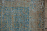 Distressed pile of an Afghani Belouch rug, with pale blue guls transitioning to a wide camel border.