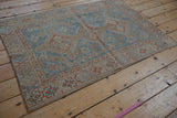 Distressed vintage Shiraz rug corner showing sky blue and terracotta geometric border.