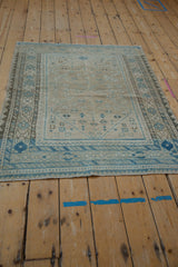 Distressed vintage Afshar rug corner with faded geometric border and diamond field patterns.