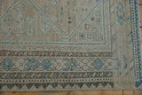 Distressed vintage Afshar rug's geometric patterns, dusty blue and oxidized silver tones.