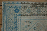Textured side selvage and geometric blue-and-silver border of a distressed Afshar rug.