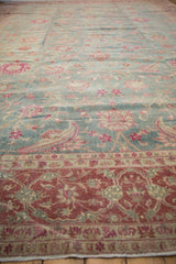 Angled view of a vintage Yezd carpet's distressed pile, showing the burgundy border and dusty blue floral field.