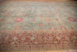 Angled view of the distressed vintage Yezd carpet showing worn texture over its floral pattern.