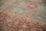 Even wear to knot heads on a Yezd rug with fuchsia palmettes on a dusty blue field and burgundy border.