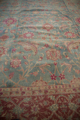 Angled view of the distressed, low-pile texture on a vintage Yezd carpet's floral pattern.