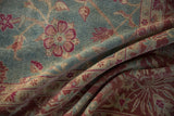 Draped vintage Yezd carpet showing the low pile and fuchsia palmettes on a dusty blue field.