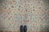 Distressed Mahal carpet, dusty blue field, burgundy floral motifs, low pile texture, with feet.