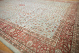 Distressed vintage Mahal carpet corner with faded powder blue field and ornate burgundy border.