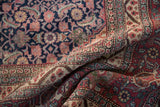 Folded vintage Tabriz carpet with navy Herati field and ivory Samovar turtle border.