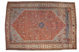 Antique Bakshaish carpet with a stepped diamond medallion, a madder red field of primitive florals, and powder blue spandrels.