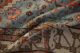 Textured low pile of a folded antique Bakshaish rug with contrasting powder blue and sand colored fields.