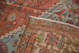 Folded corner of an antique Bakshaish carpet displaying its colorful low pile and hand-knotted foundation.