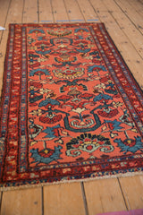 Hand-knotted texture and large floral blossoms in blush, blue, and red tones.