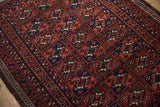 Vintage Belouch rug section with paneled guls, wine red, navy, brown tones, and intact selvage.