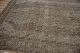 Distressed vintage Shiraz carpet showing worn texture, coffee, bronze, and pale teal geometric motifs.
