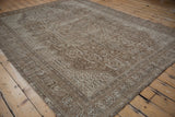 Distressed vintage Shiraz carpet showing worn pile and coffee brown geometric patterns.