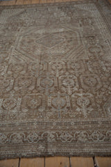 Distressed brown geometric border and field patterns on this vintage Shiraz carpet.