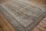 Distressed vintage Shiraz carpet corner, showcasing foundation and muted brown, ivory patterns.