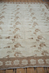 Angled view of the vintage Oushak carpet's short pile texture and repeating floral sprays.