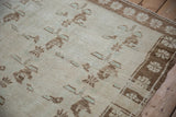 Short pile texture on a vintage Oushak rug with brown and mint green floral spray details.